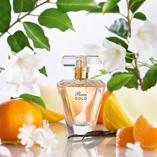 Rare Gold Perfume surrounded by citrus fruits and lilies